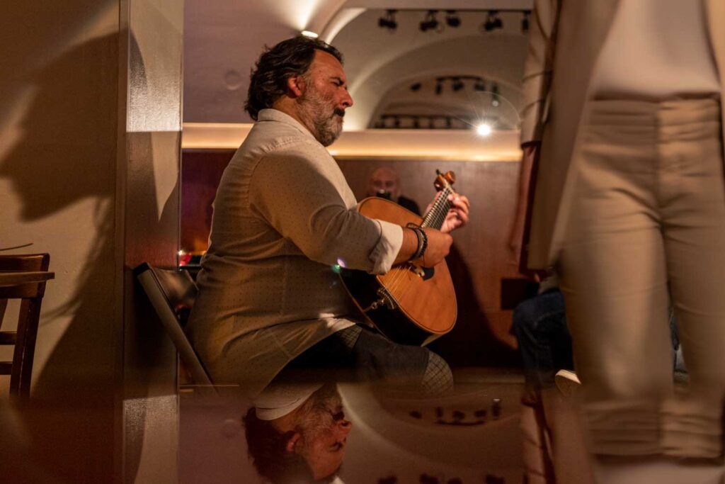 Portuguese man playing Portuguese guitar at a bar in Lisbon, Portugal