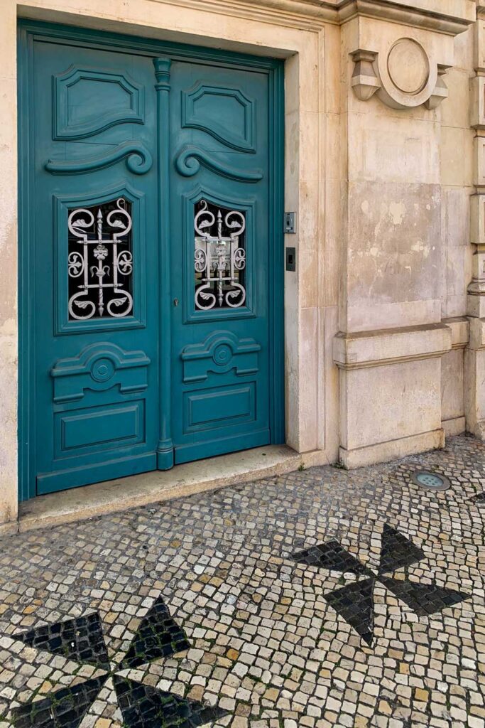 a photo of a beautiful blue door with black and white tile floor