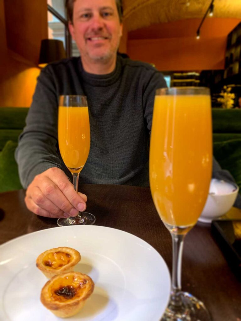 a man enjoying Pastéis de Nata and a mimosa for brunch at Vignette Collection Casa da Companhia in Porto, Portugal